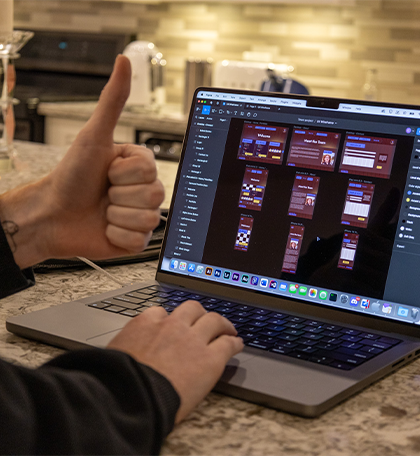 A hand giving a thumbs up to a screen with Figma open